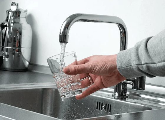 Running tap filling a glass of water